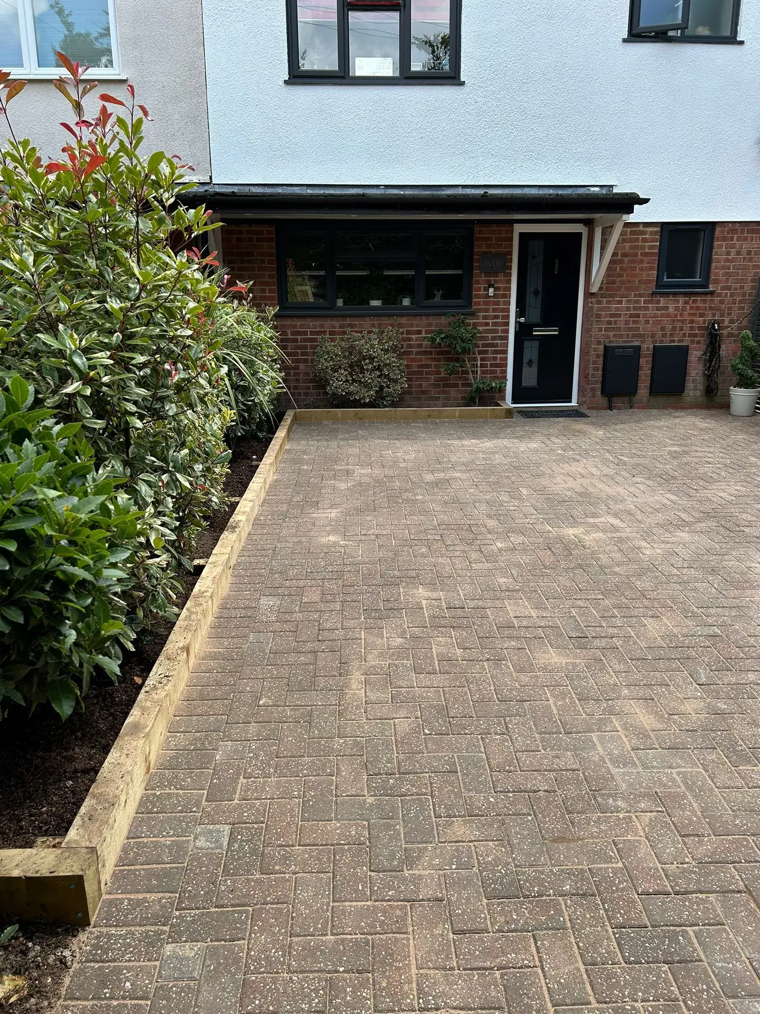 A brick driveway in front of a house.