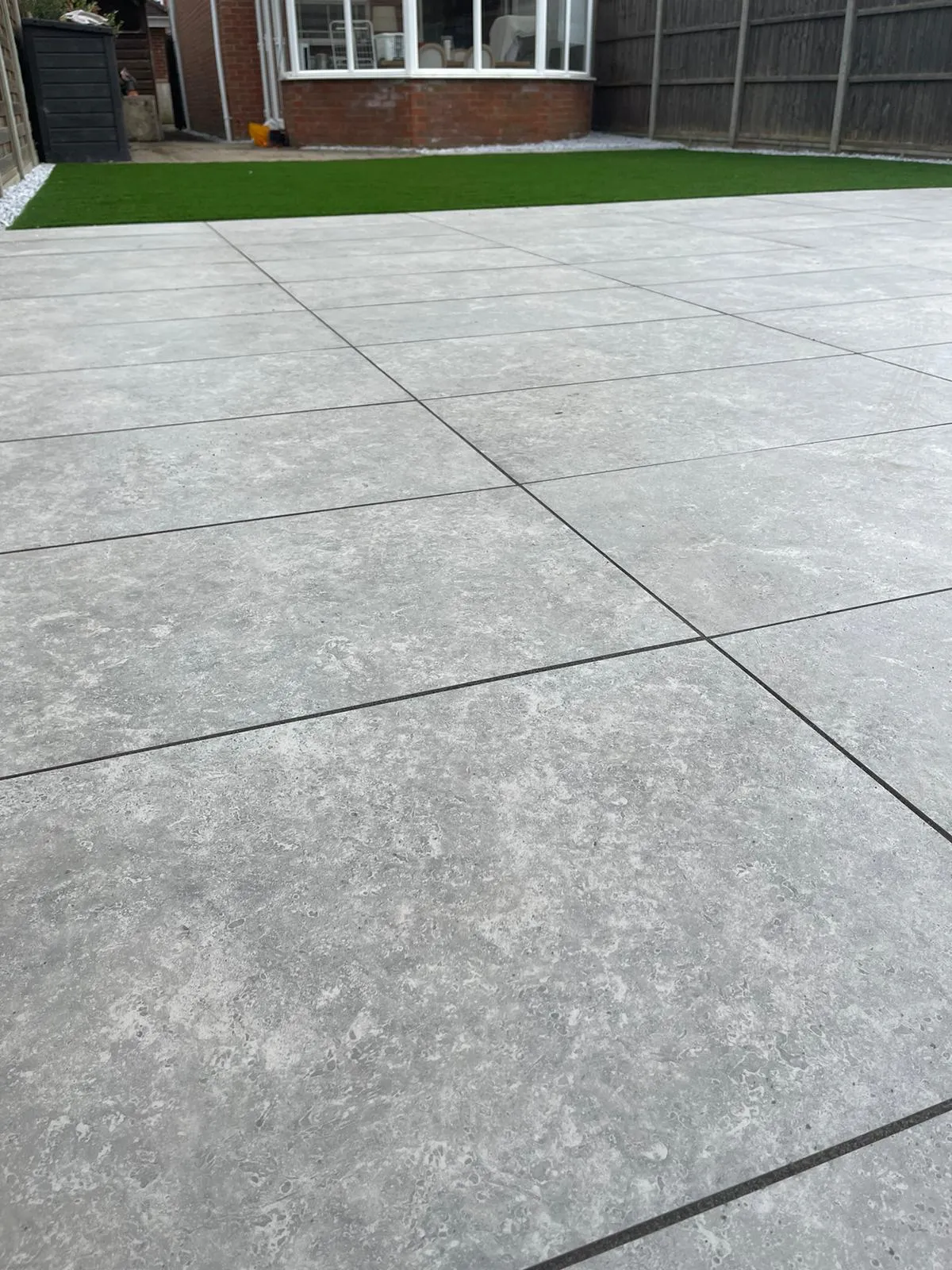 a concrete patio with grass in the background