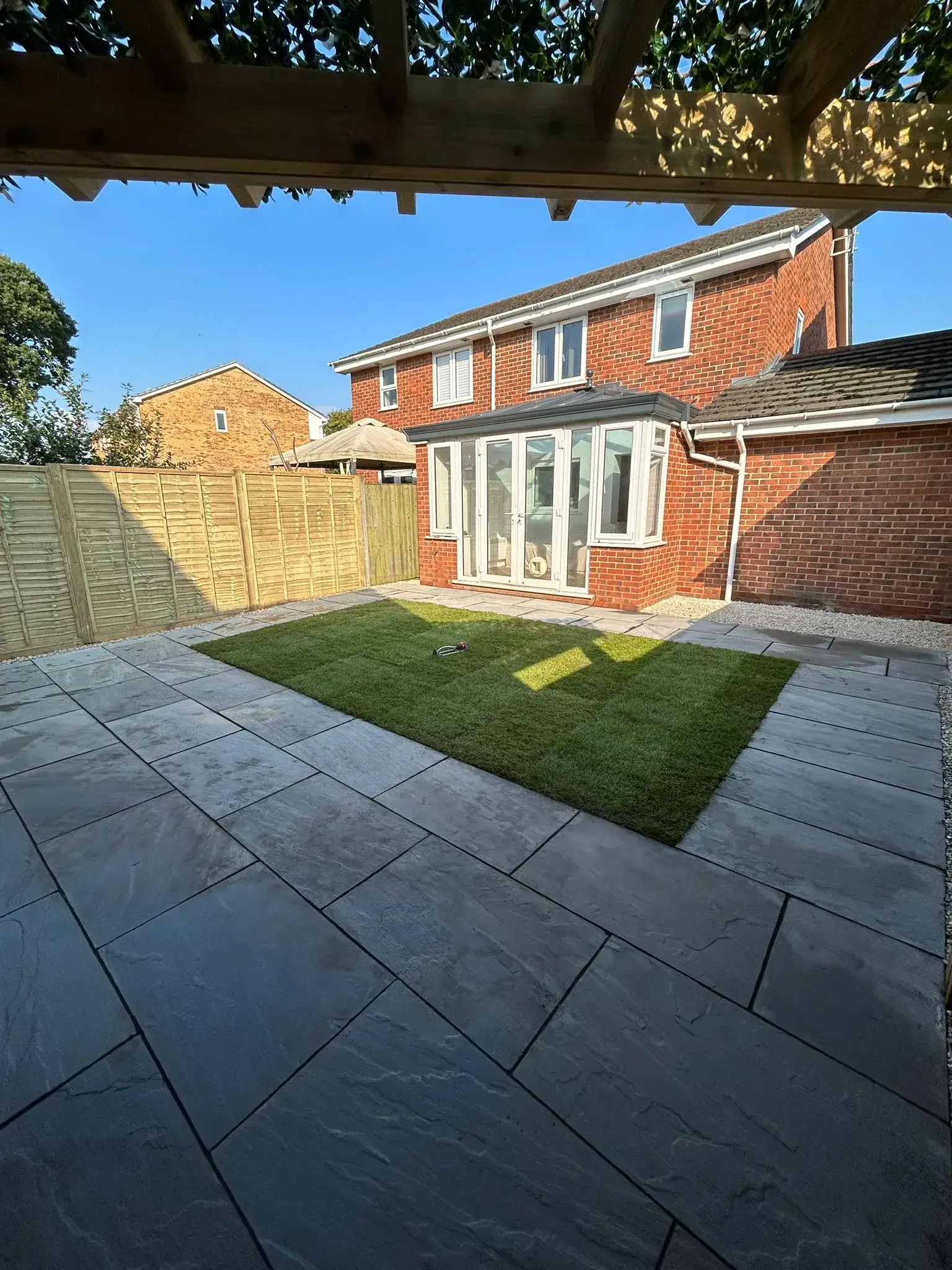 A backyard with a lawn and a fence.